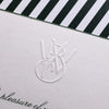 White card with black and white striped border and embossed logo