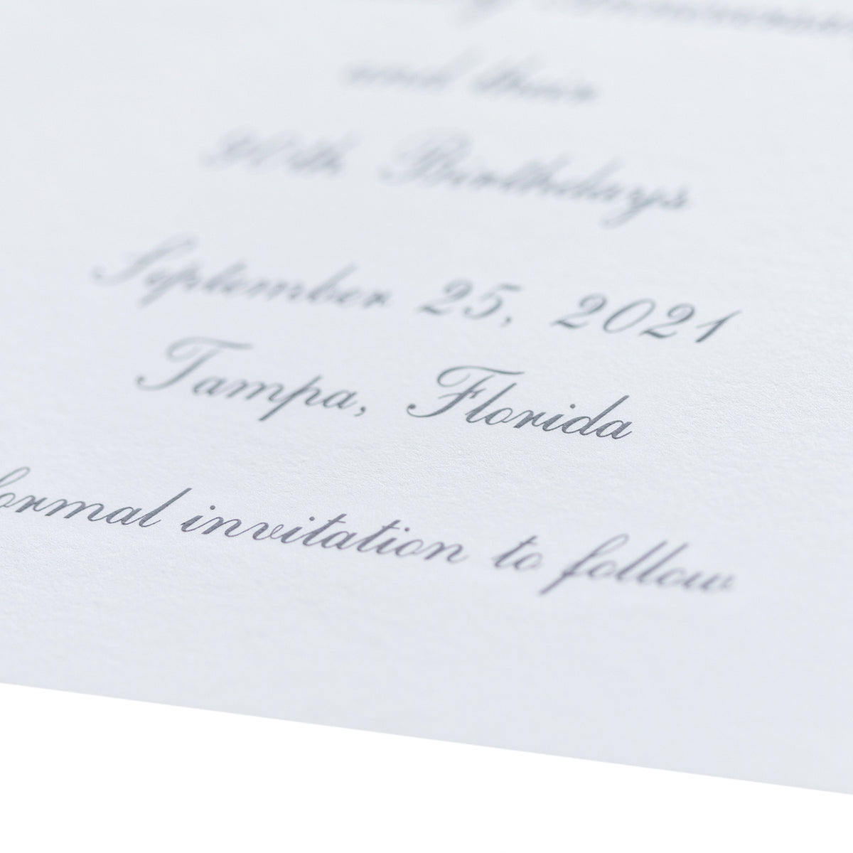 Close-up of an elegant white engraved card with cursive text, featuring the date September 25, 2021, Tampa, Florida, and the phrase "formal invitation to follow" as a beautiful save the date.